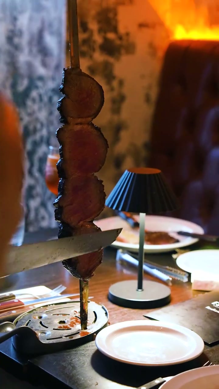 Estábulo steak being carved from a skewer at the table